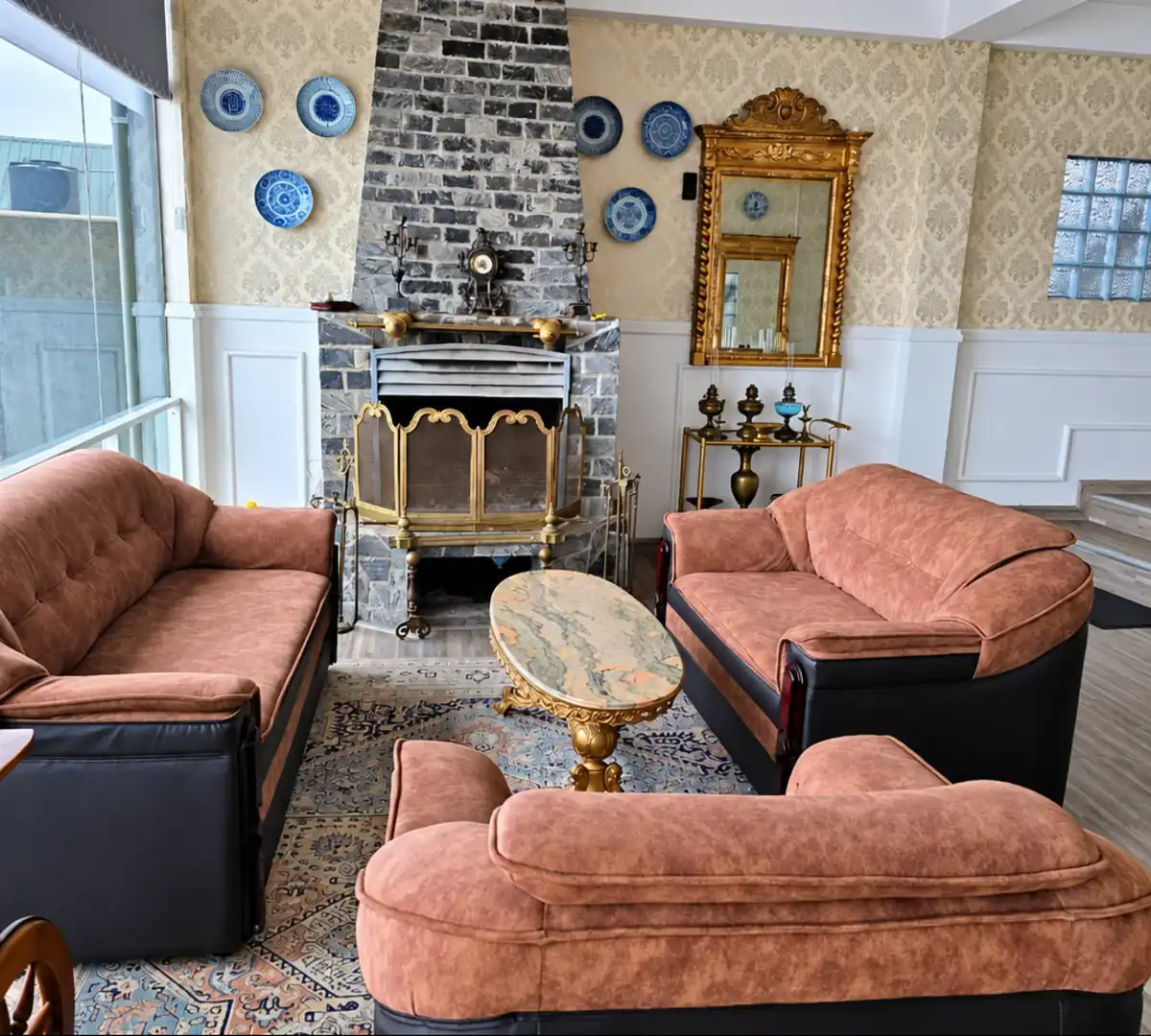 Communal lounge arranged around the stone fireplace